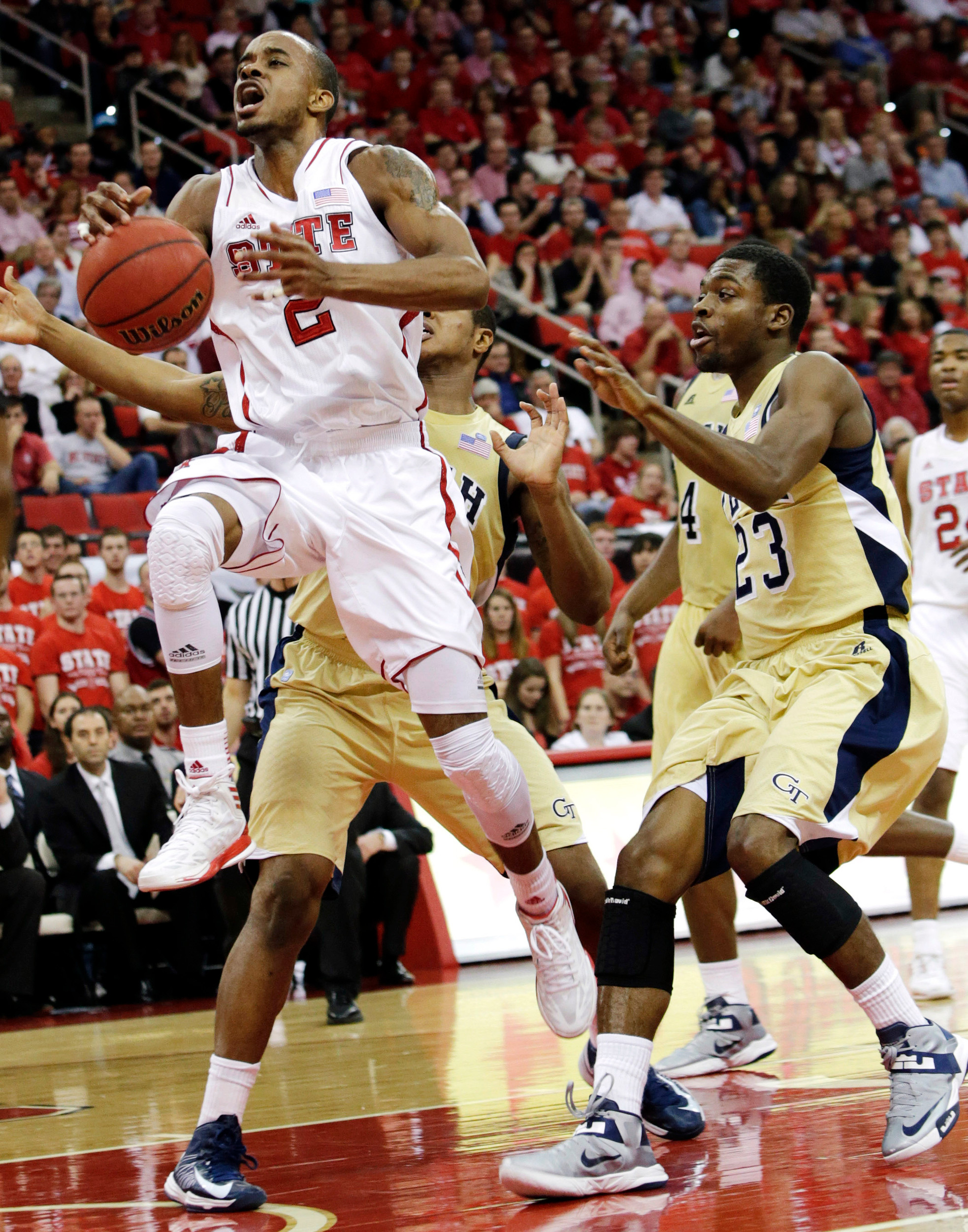 North Carolina State's Lorenzo Brown drives to the basket past Georgia Tech's Marcus Georges-Hunt and Brandon Reed (23) during the first half of an NCAA college basketball game in Raleigh, N.C., Wednesday, Jan. 9, 2013. (AP Photo/Gerry Broome)