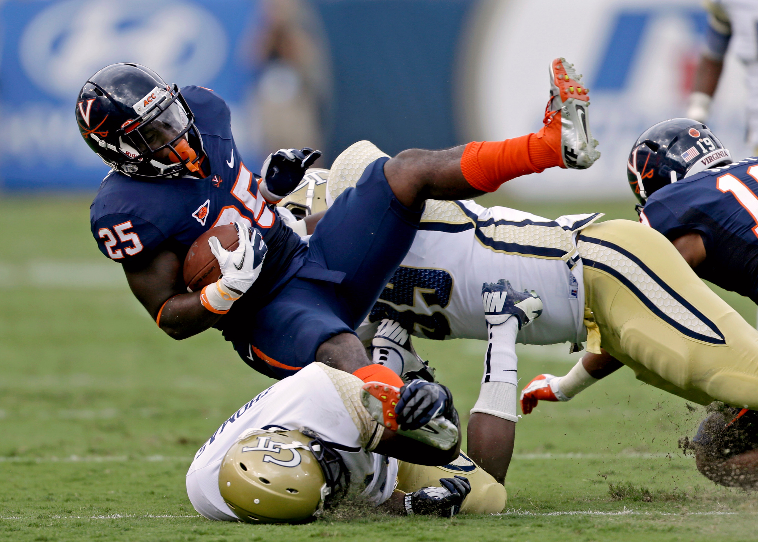 Virginia running back Kevin Parks (25) is tackled by Georgia Tech's Jemea Thomas, left, and Euclid Cummings, rear, in the first quarter. Georgia Tech won 56-20. (AP Photo/David Goldman)