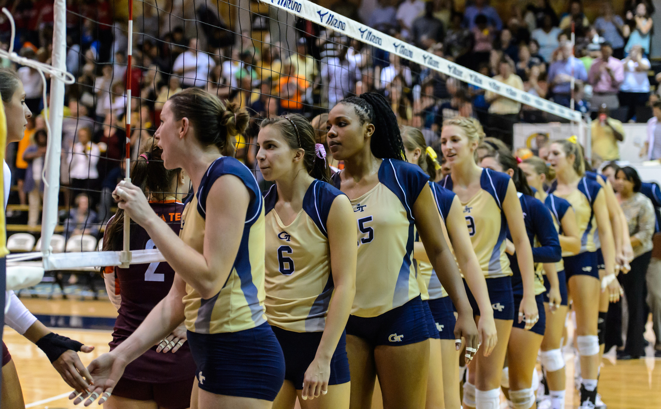 The Yellow Jackets shake hands at the net after the match.