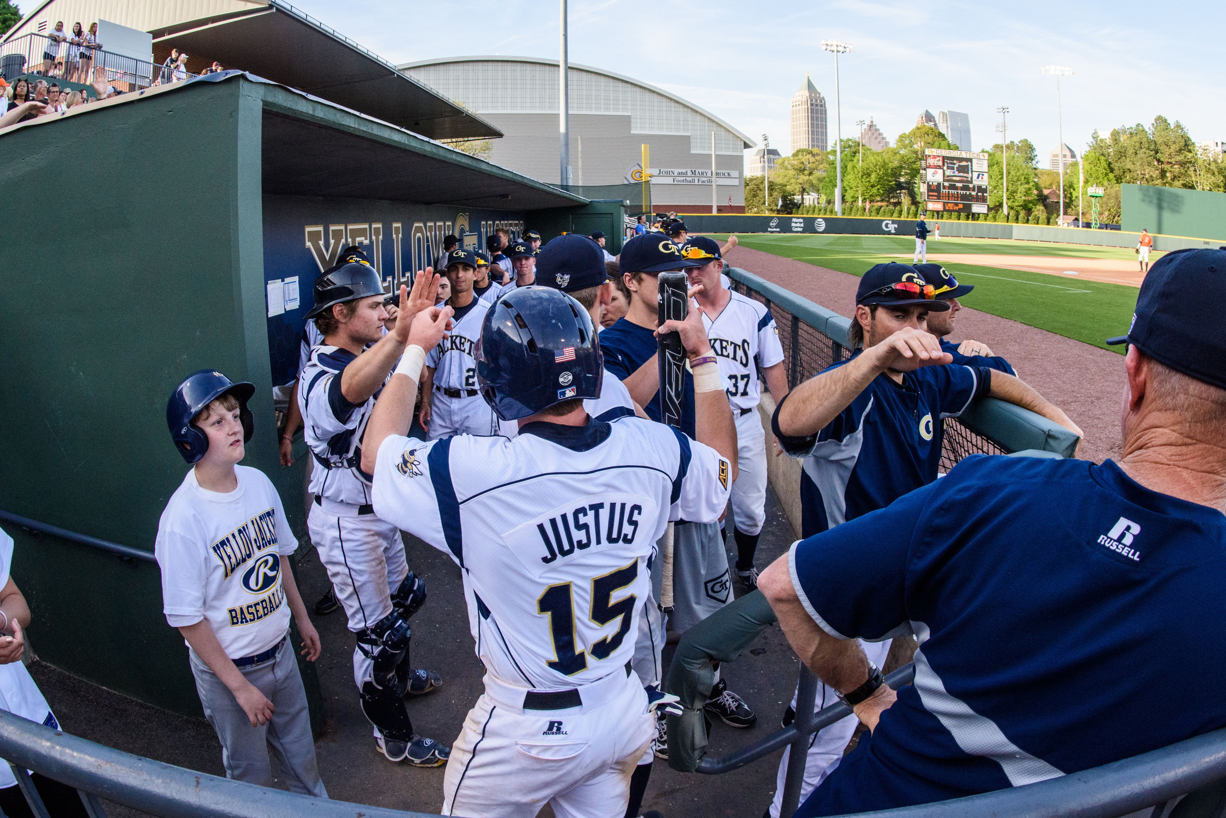 Connor Justus (15) is welcomed back to the dugout after scoring a run