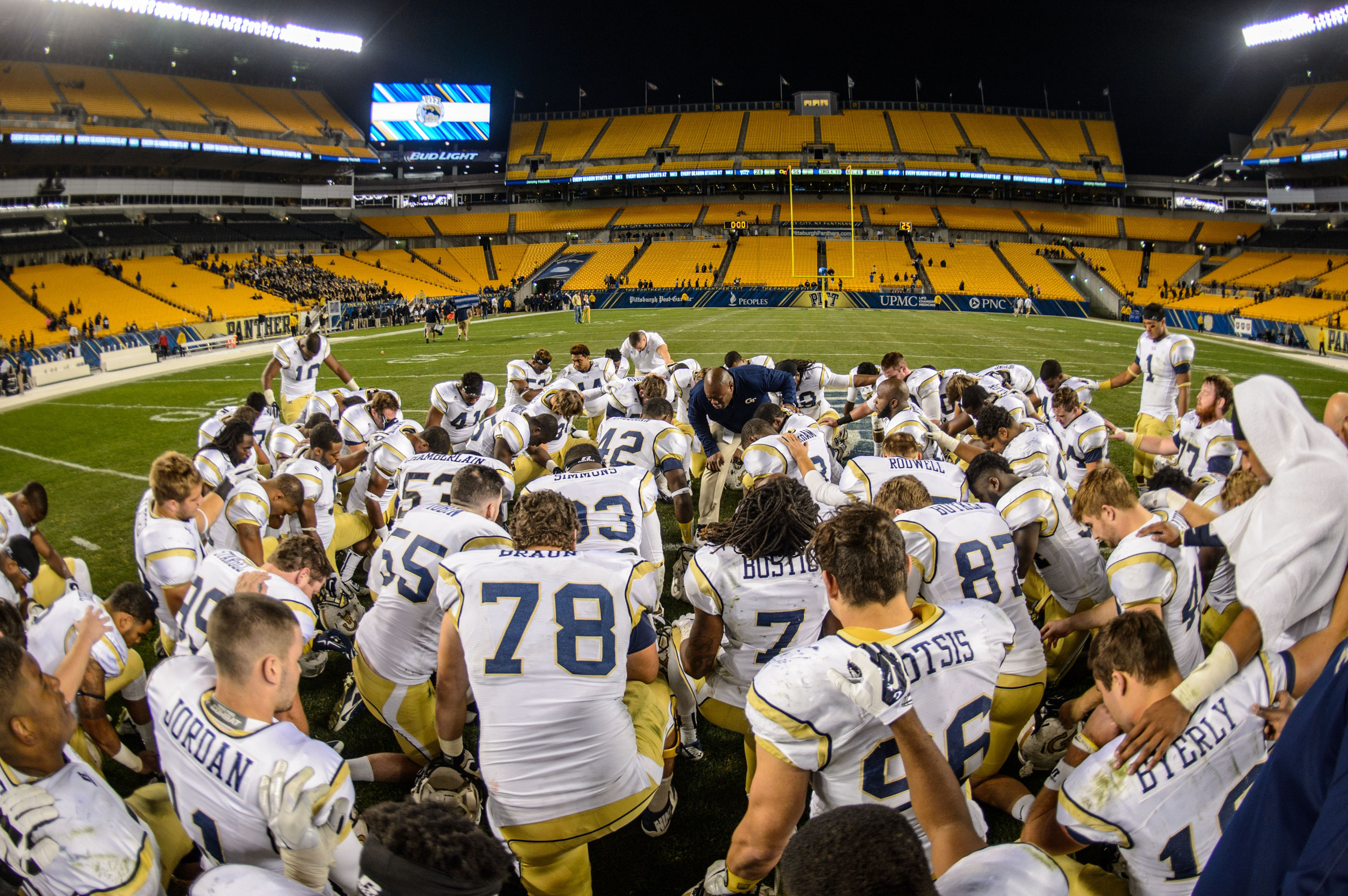 The team prays at midfield after the win