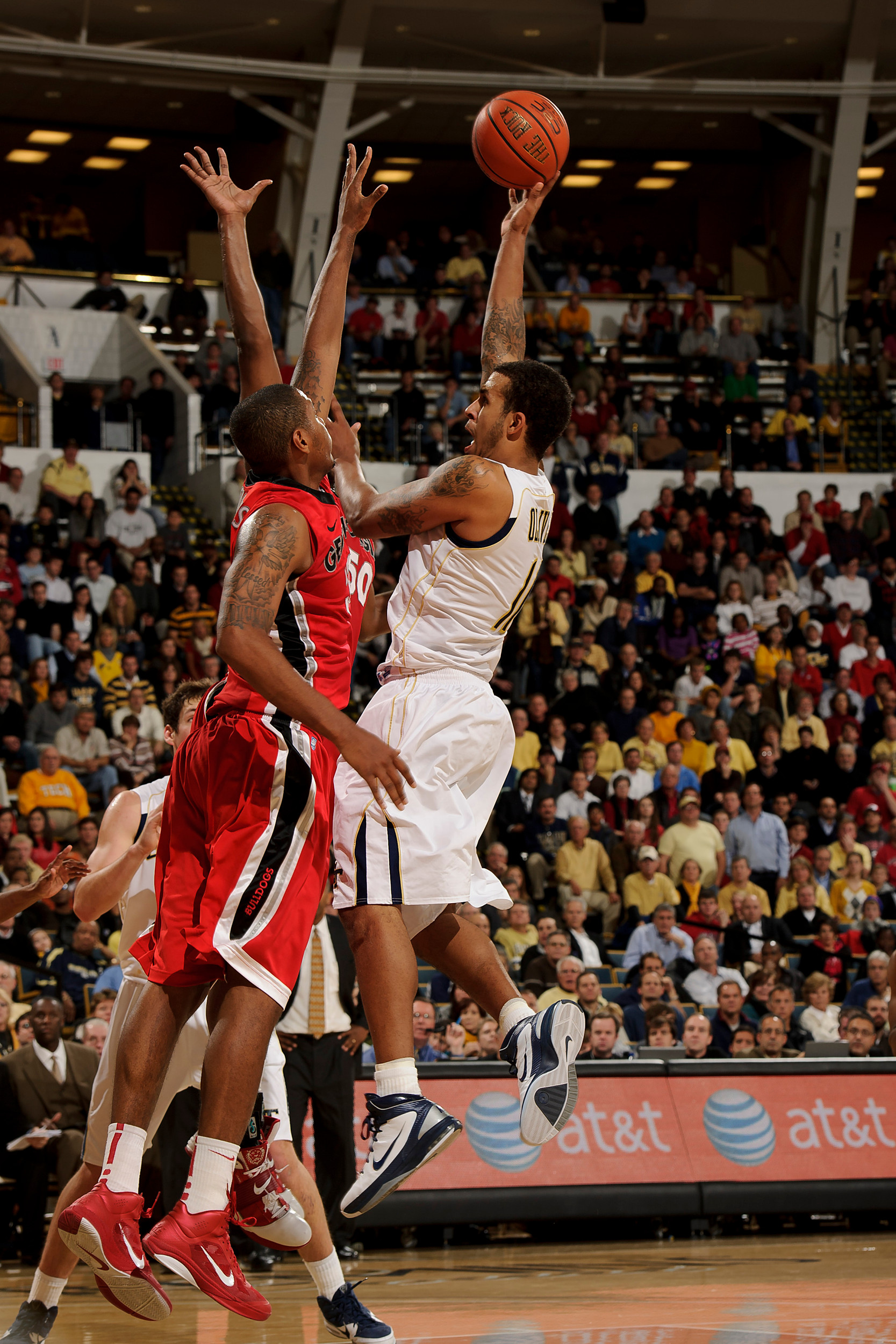 Dec 7, 2010; Atlanta, GA, USA; Georgia Tech Yellow Jackets forward Brian Oliver (11) shoots over Georgia Bulldogs forward Trey Thompkins (33) during the second half at Alexander Memorial Coliseum. Georgia defeated Georgia Tech 73-72. Mandatory Credit: Paul Abell-US PRESSWIRE