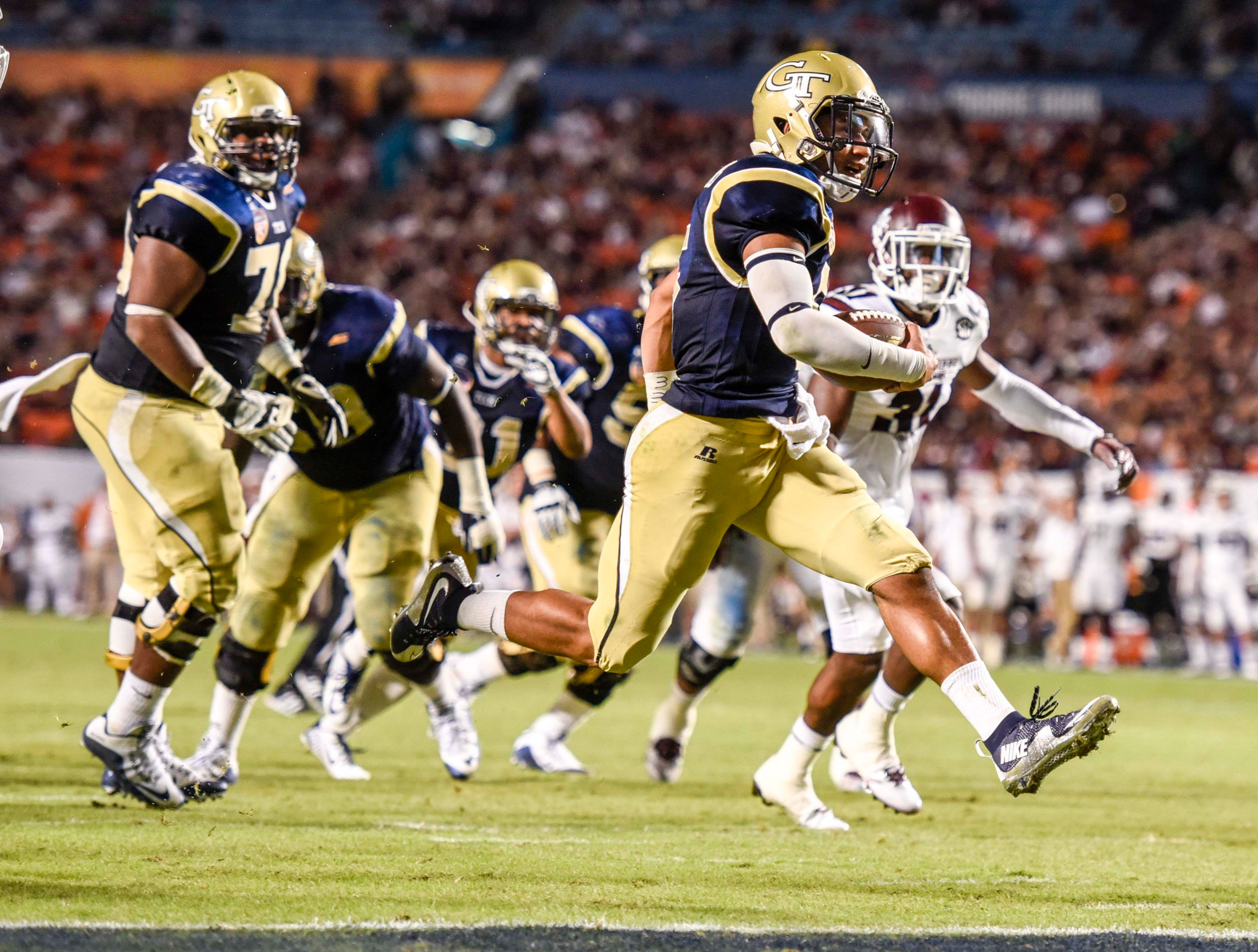 Dec 31, 2014; Miami Gardens, FL, USA; Georgia Tech Yellow Jackets quarterback Justin Thomas (5) scores a touchdown against the Mississippi State Bulldogs in the second half of the Orange Bowl game at Sun Life Stadium. Georgia Tech defeated the Bulldogs 49-34. Mandatory Credit: Brad Barr-USA TODAY Sports