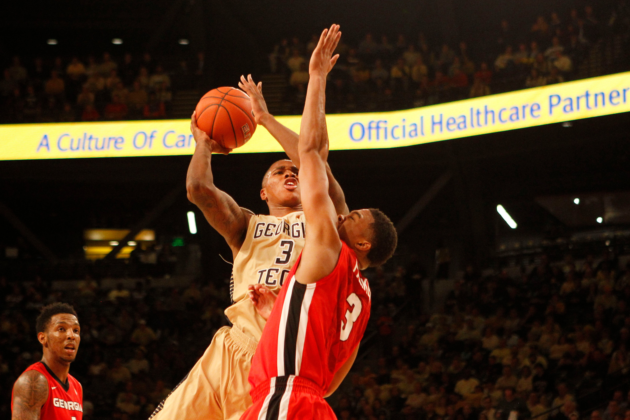 Nov 14, 2014; Atlanta, GA, USA; Georgia Tech Yellow Jackets forward Marcus Georges-Hunt (3) shoots the ball over Georgia Bulldogs guard Juwan Parker (3) in the first half at McCamish Pavilion.
