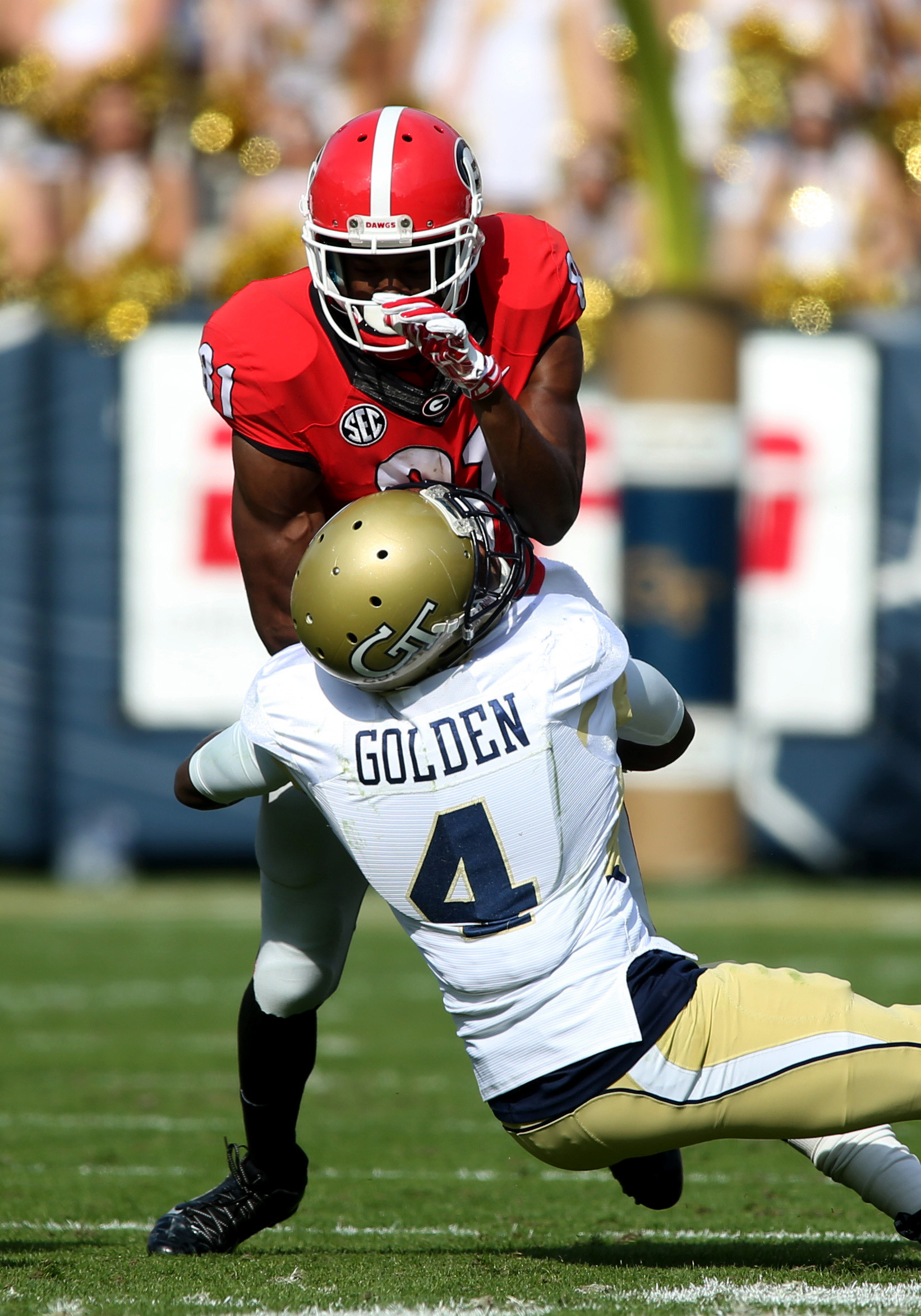 Georgia Tech Yellow Jackets defensive back Jamal Golden (4) tackles Georgia Bulldogs wide receiver Reggie Davis (81) after a run in the first quarter of their game at Bobby Dodd Stadium. Jason Getz-USA TODAY Sports