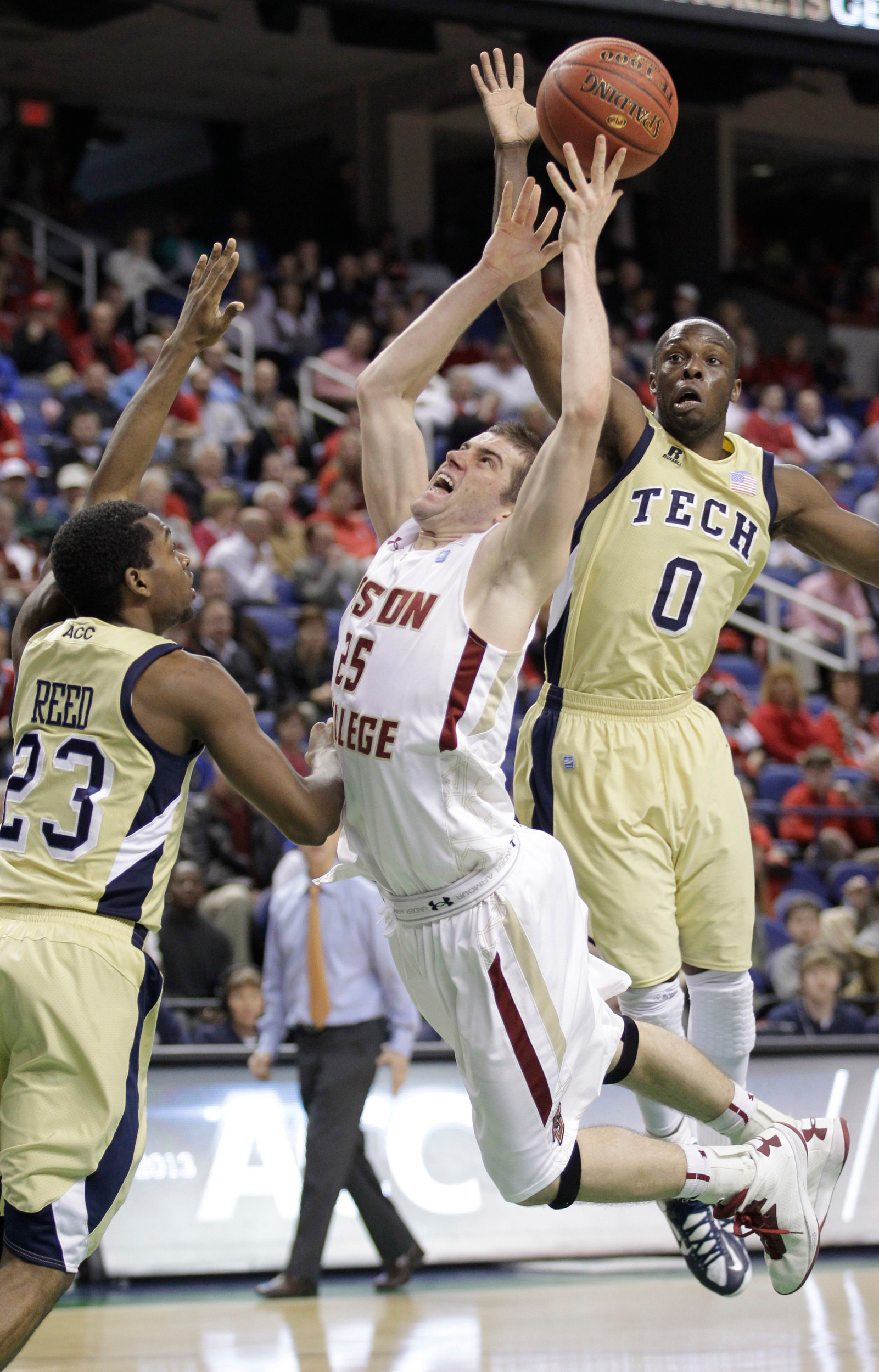 Boston College's Joe Rahon (25) is fouled as he drives between Georgia Tech's Mfon Udofia (0) and Brandon Reed (23). (AP Photo/Bob Leverone)