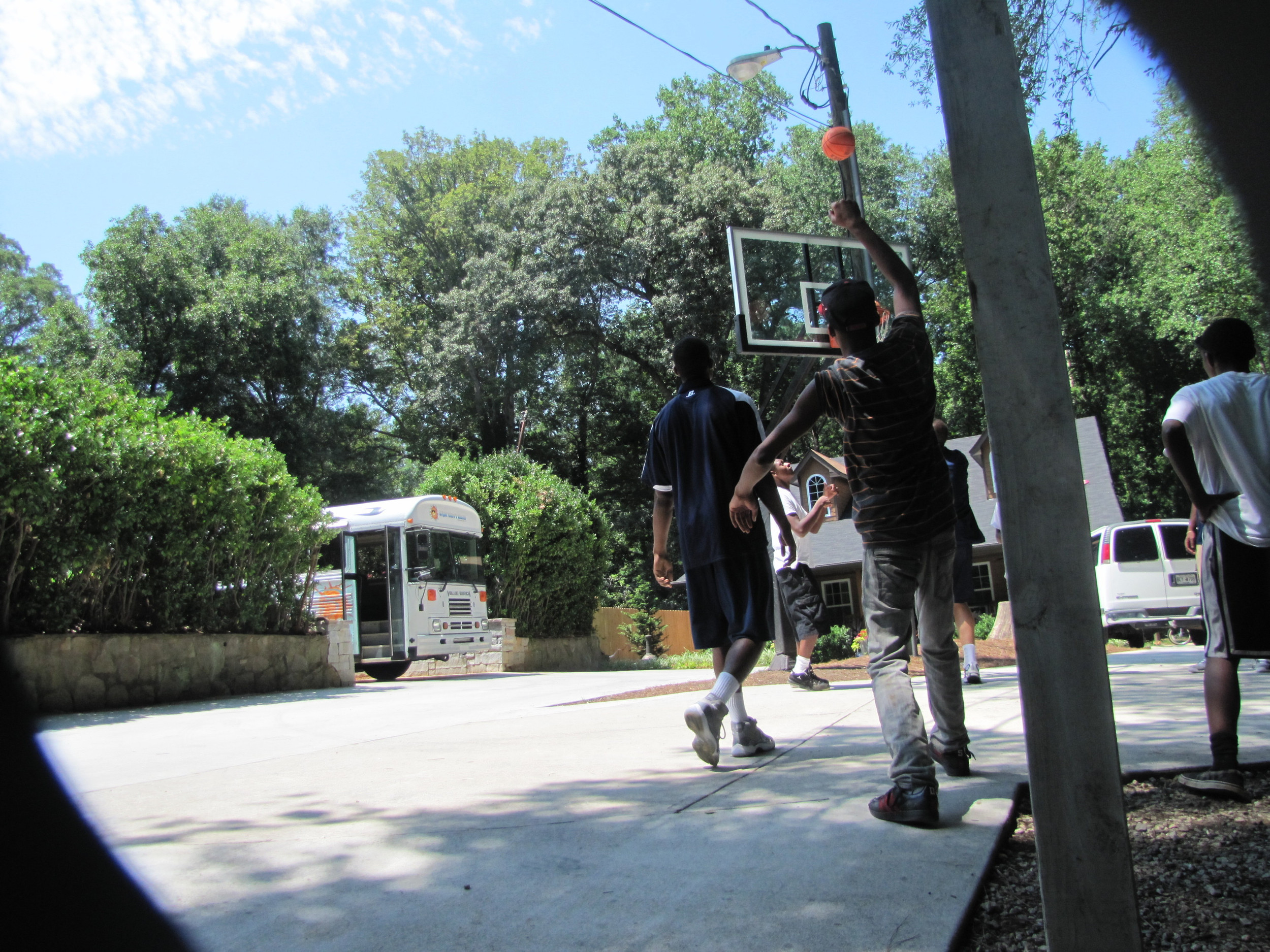 Kammeon Holsey, Daniel Miller, Brandon Reed and Glen Rice. Jr., play pick-up with the kids at Bright Futures Academy.