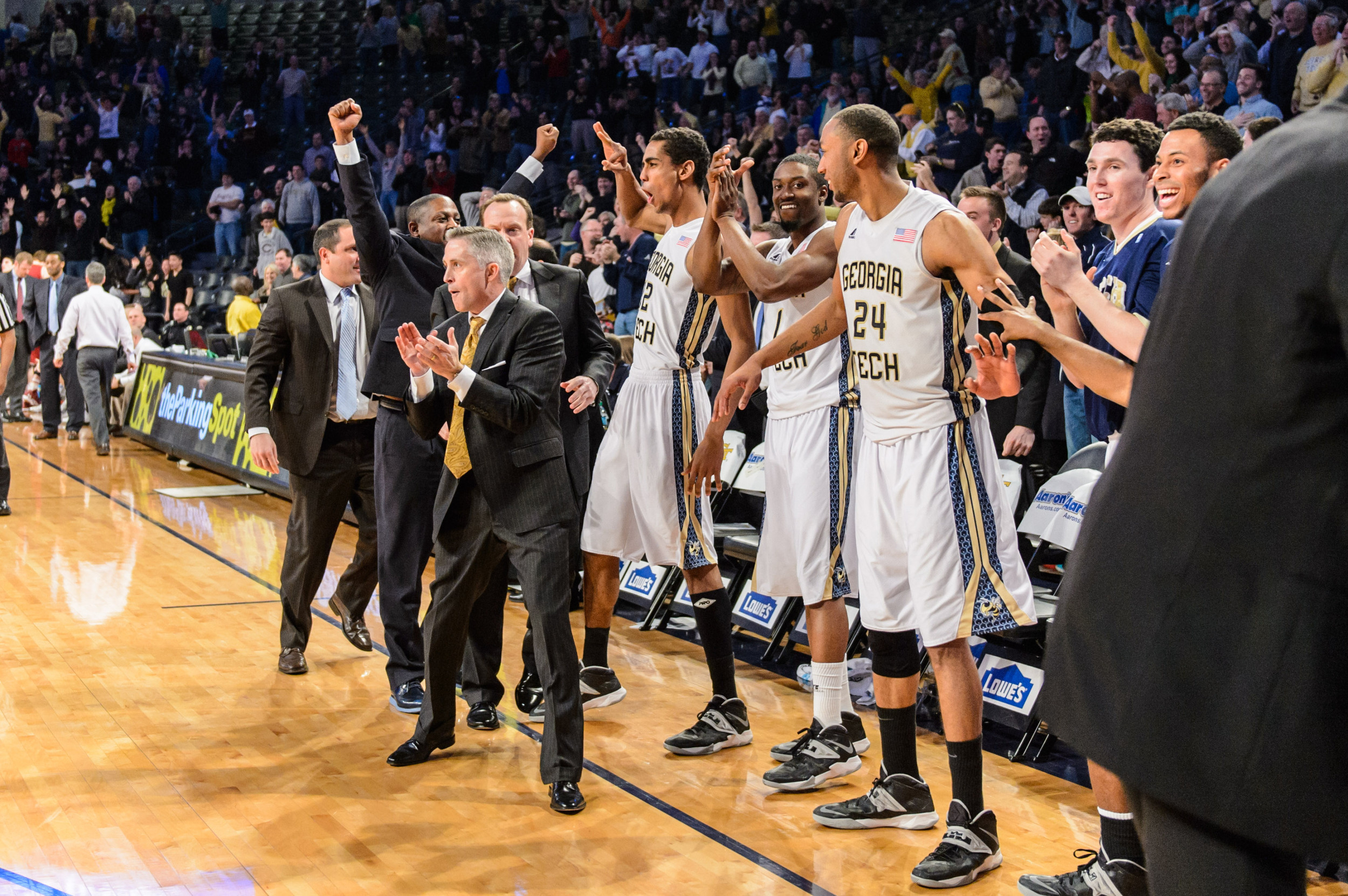 The bench reacts to Marcus Georges-Hunt's 3-pointer