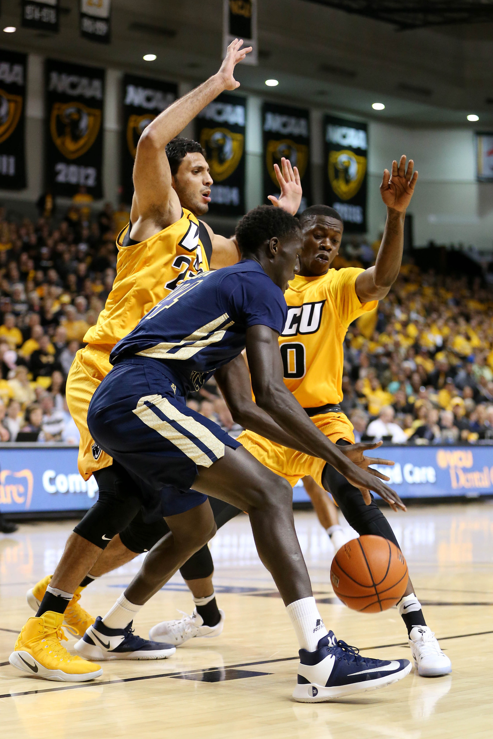 Dec 7, 2016; Abdoulaye Gueye (34) dribbles the ball as Virginia Commonwealth Rams forward Ahmed Hamdy-Mohamed (23) and Rams guard De'Riante Jenkins (0). Credit: Amber Searls-USA TODAY Sports