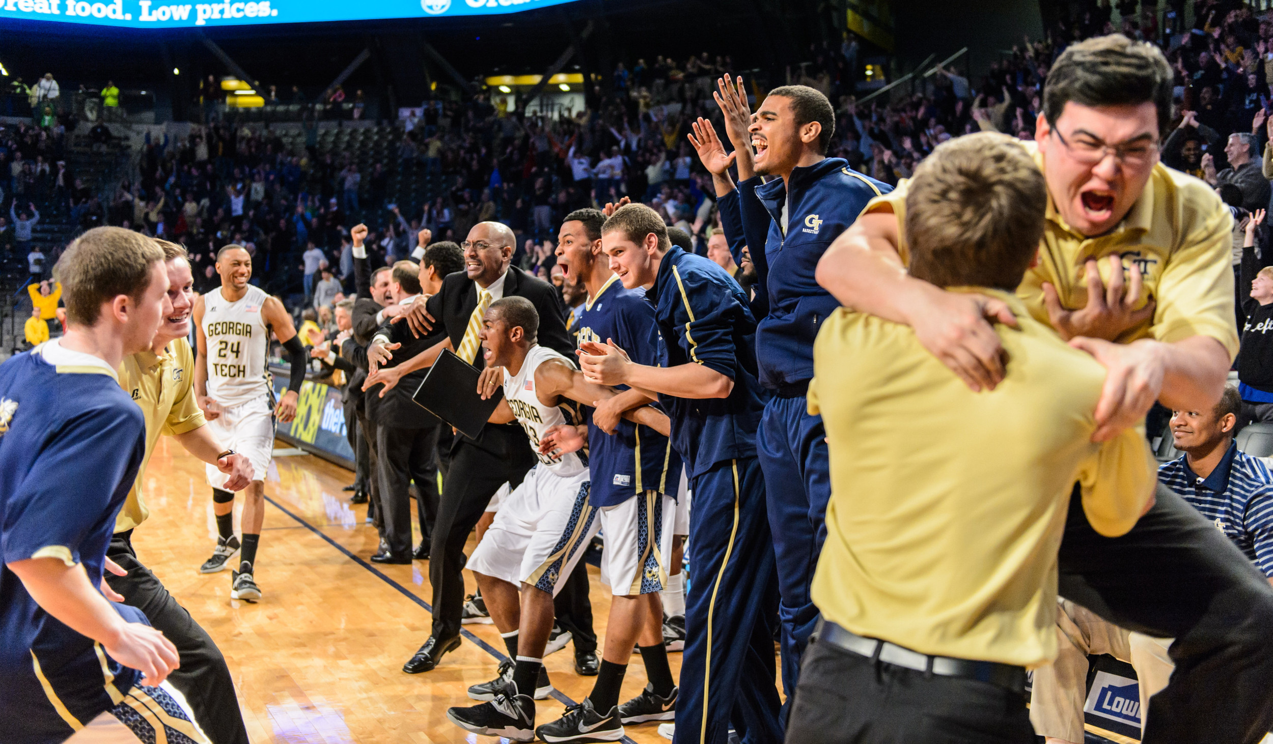 The bench reacts to Marcus Georges-Hunt's 3-pointer