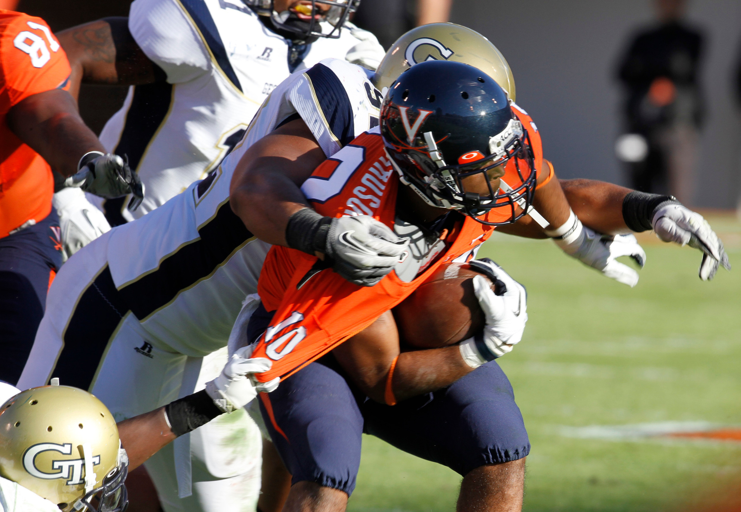 Virginia running back Clifton Richardson (10) gets hauled down by Georgia Tech defensive end Jason Peters, top, and cornerback Rod Sweeting, left, during the first half. (AP Photo/Steve Helber)