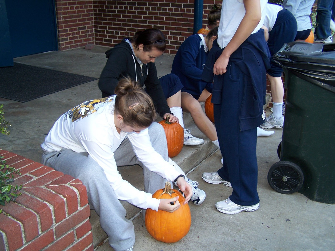 Allie Niekamp and volunteer assistant coach Kele Eveland start their pumpkins.