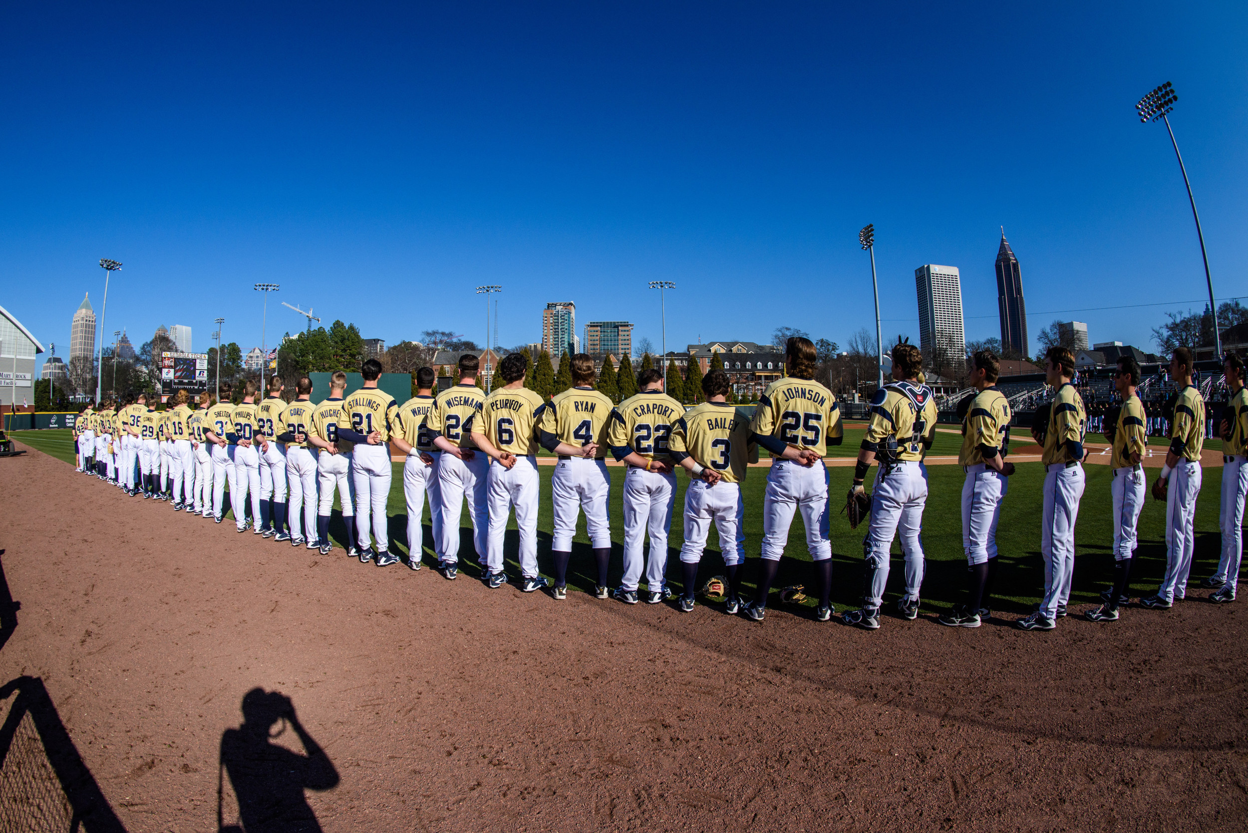 The team lines the bases for the national anthem
