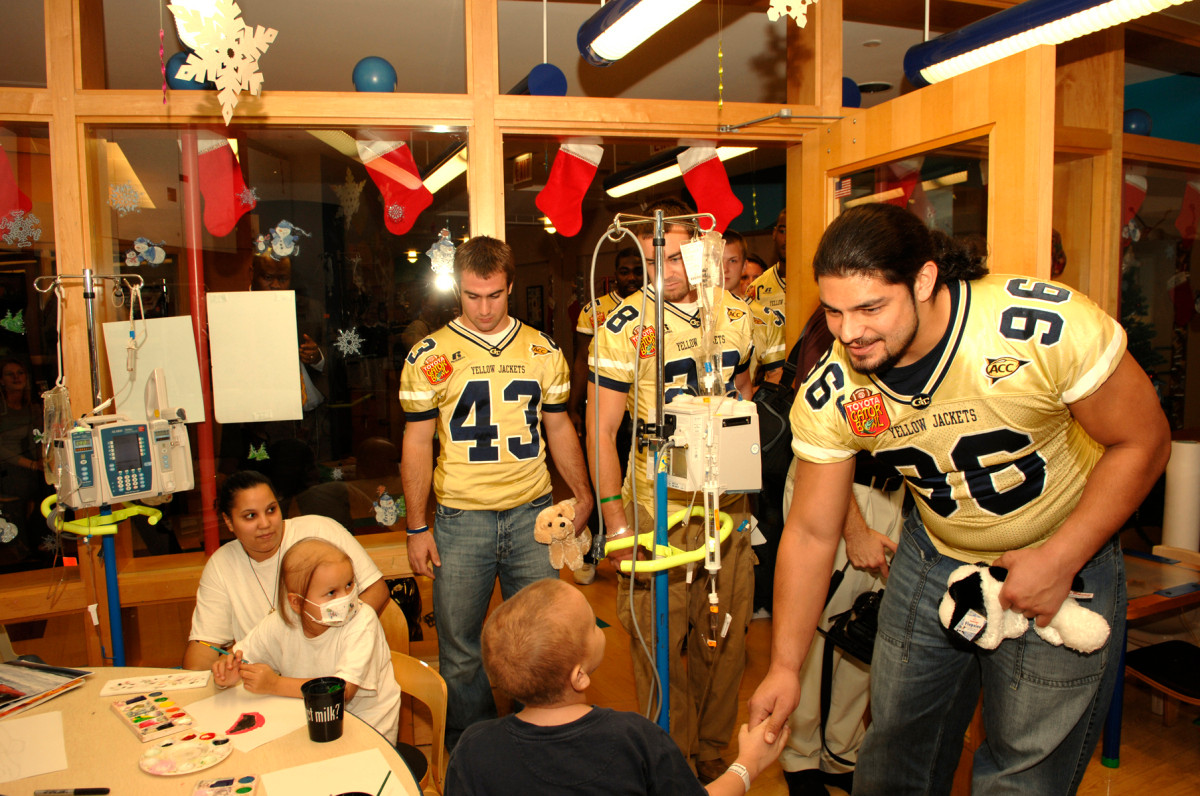 Joe Anoai and other Tech players make friends with the children at Wolfson's Hospital.