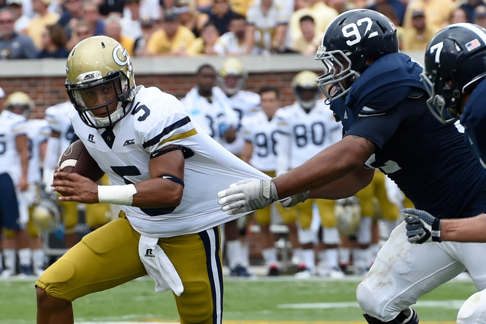 Sep 13, 2014; Atlanta, GA, USA; Yellow Jackets quarterback Justin Thomas (5) tries to break free of a tackle by Georgia Southern Eagles defensive lineman Jonathan Battle (92) during the first half. Dale Zanine-USA TODAY Sports