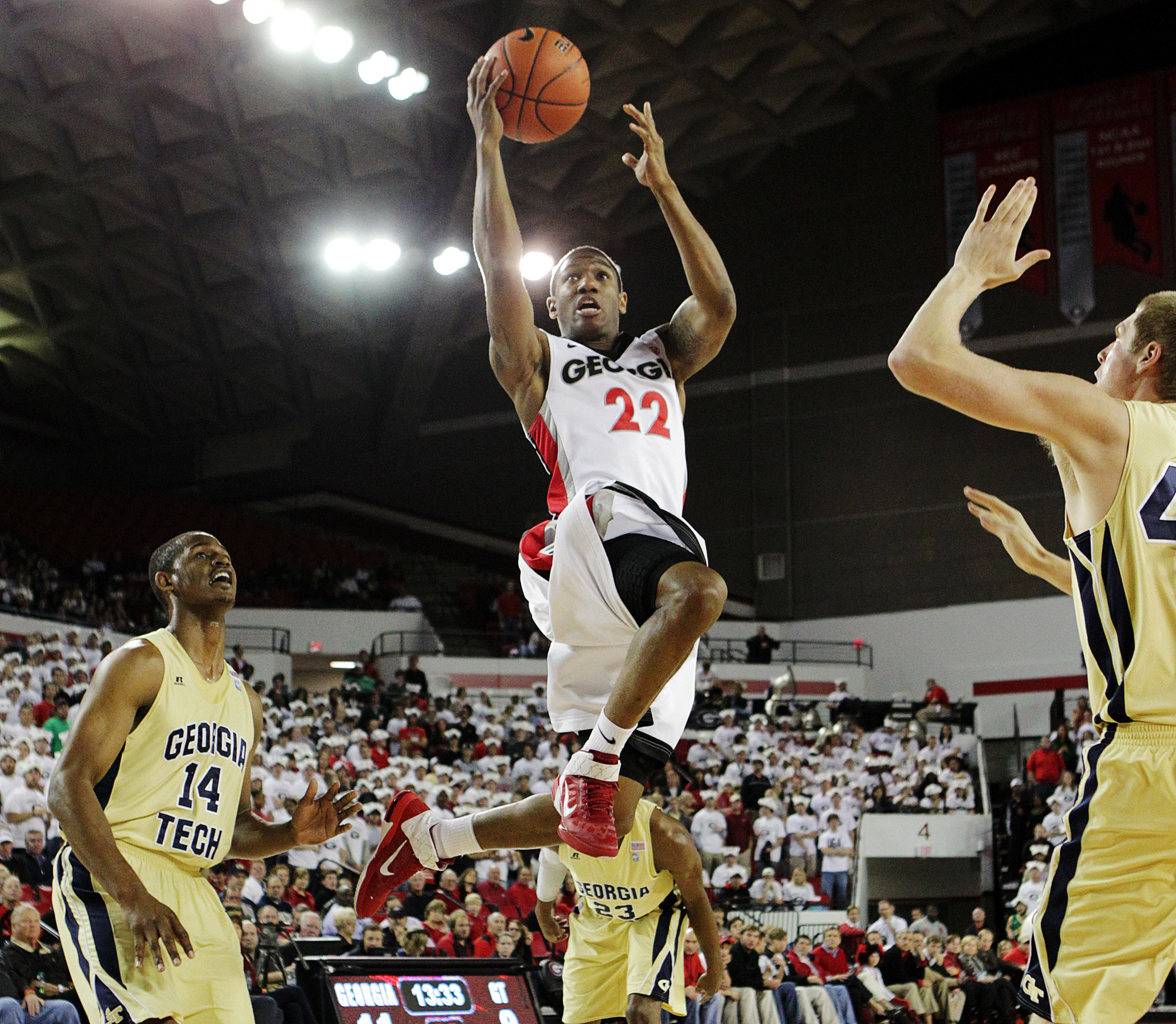 Georgia guard Gerald Robinson, Jr. (22) splits Georgia Tech defenders Jason Morris (14), Brandon Reed (23) and Nate Hicks on his way to the basket for a layup during the first half of an NCAA college basketball game, Wednesday, Dec. 7, 2011, in Athens, Ga. (AP Photo/Atlanta Journal & Constitution, Curtis Compton) MARIETTA DAILY OUT; GWINNETT DAILY POST OUT