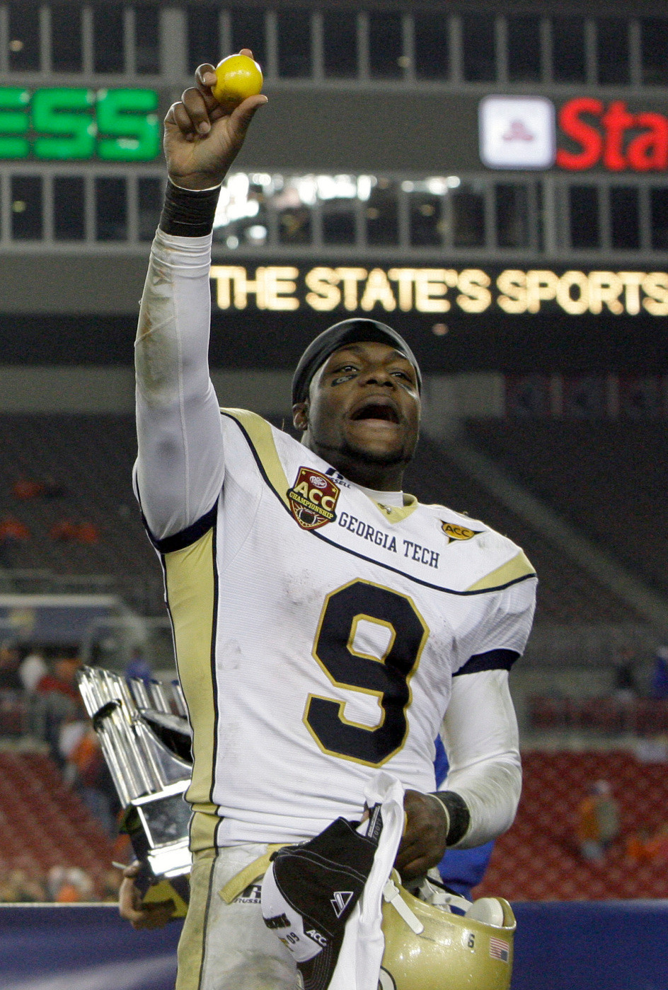Georgia Tech quarterback Josh Nesbitt throws an orange to fans.