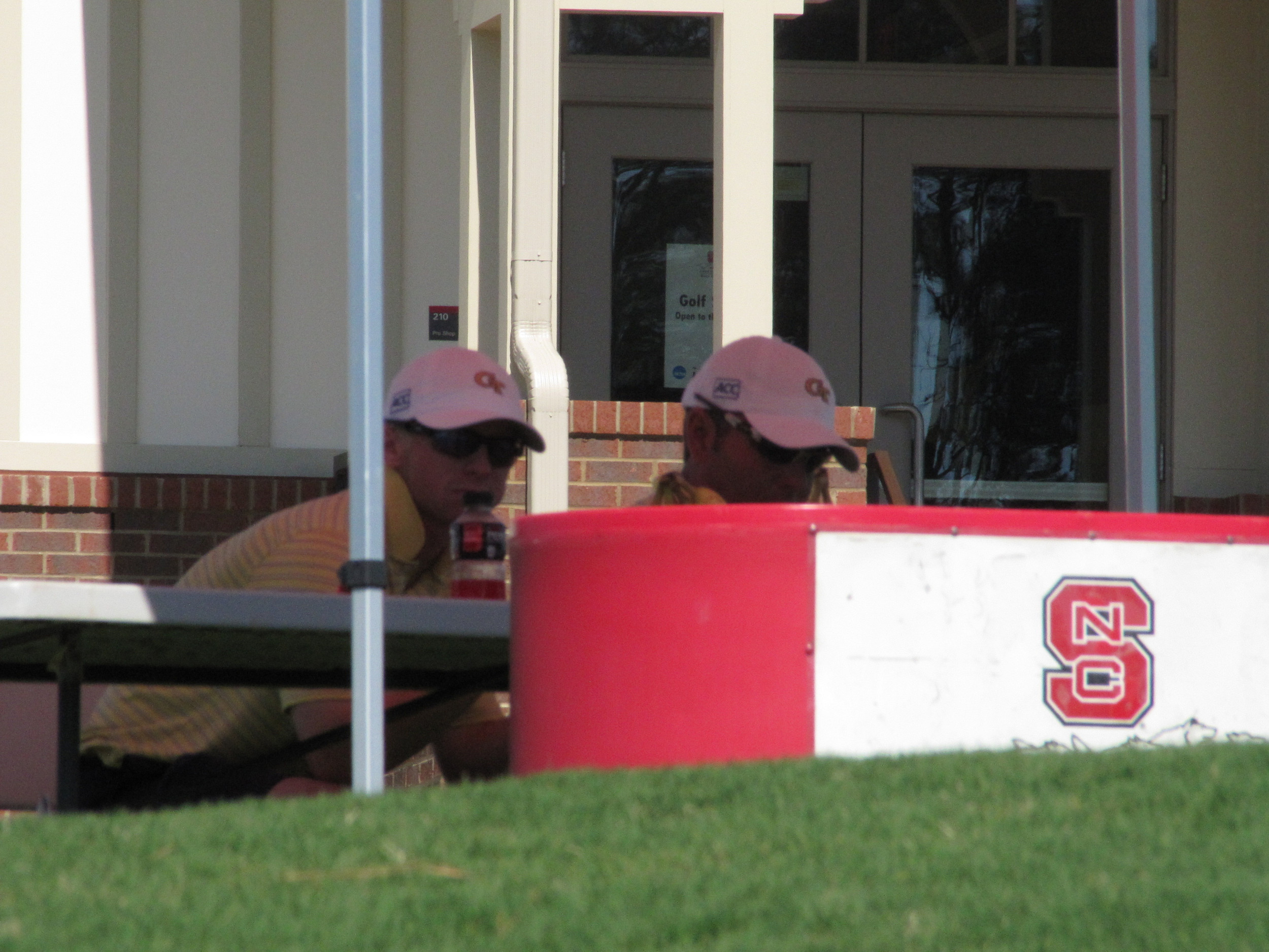 Anders Albertson and assistant coach Brennan Webb have a snack during a backup in play Friday at the NCAA Raleigh Regional, May 16, 2014