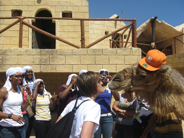 Asst Coach Teri Moren shows some teeth while feeding the camel