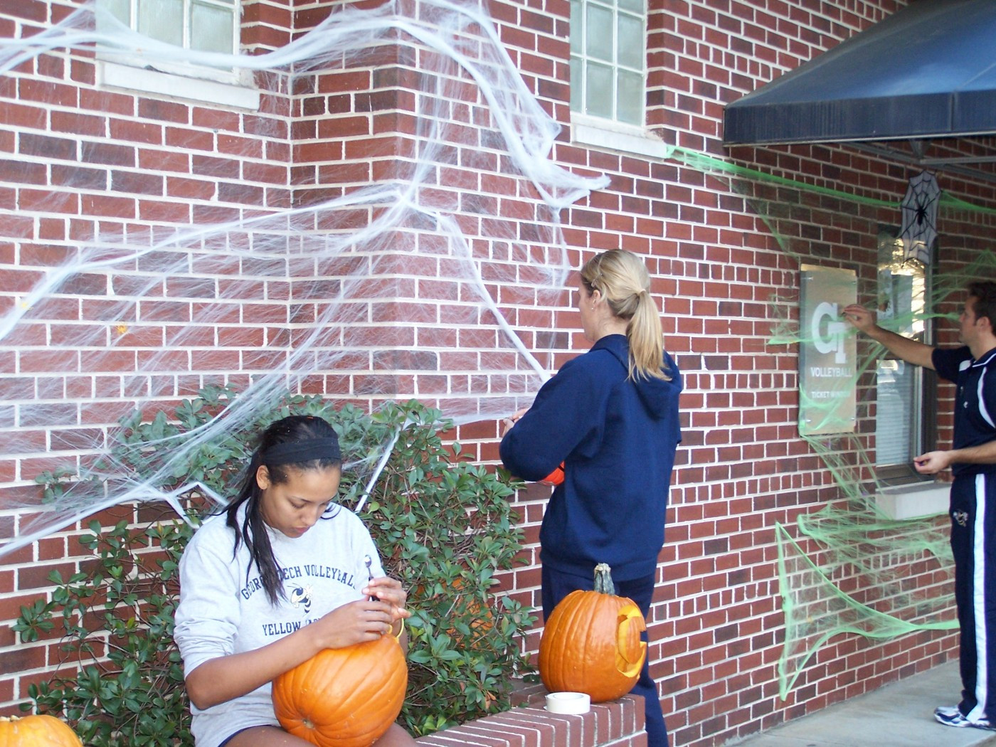 Assistant coach Jennifer Carey and head coach Bond Shymansky continued decorating O'Keefe Gym while the team carved pumpkins.