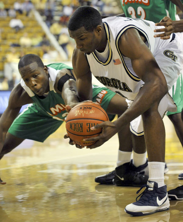 Georgia Tech forward Gani Lawal, right, fights Florida A&M forward Yannick Crowder, left, for a loose ball during the first half.