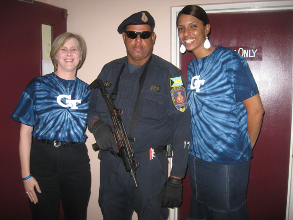 Karen Sugrue and LaChina Robinson take a photo with the security guard at the gymnasium. They carry some serious weapons.