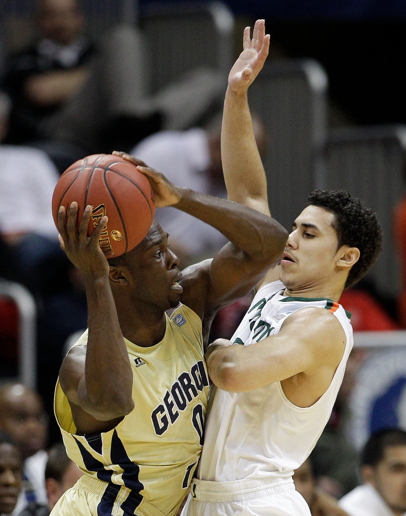 Georgia Tech guard Mfon Udofia, left, works against Miami guard Shane Larkin during the first half. (AP Photo/Chuck Burton)