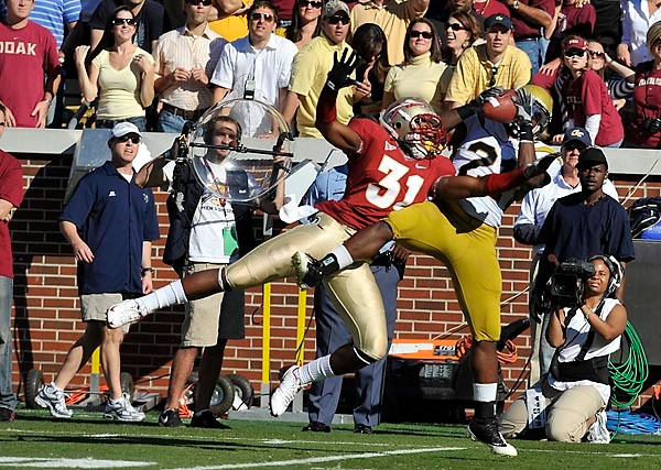 Jonathan Dwyer (21) hauls in a pass against FSU's Toddrick Verdell. Photo by LensEffects