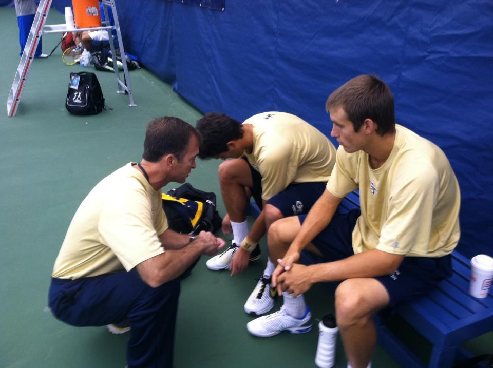 Kenny Thorne gives Kevin King and Juan Spir a pep talk before their doubles match.