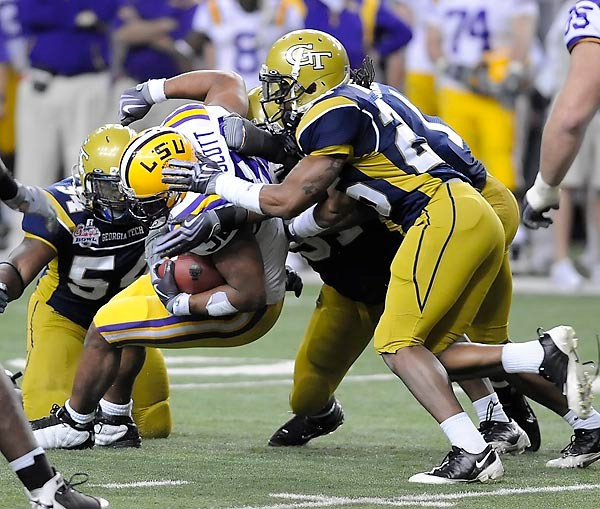 Georgia Tech defenders swarm to the ball to stop the LSU carrier. Photo by LensEffects