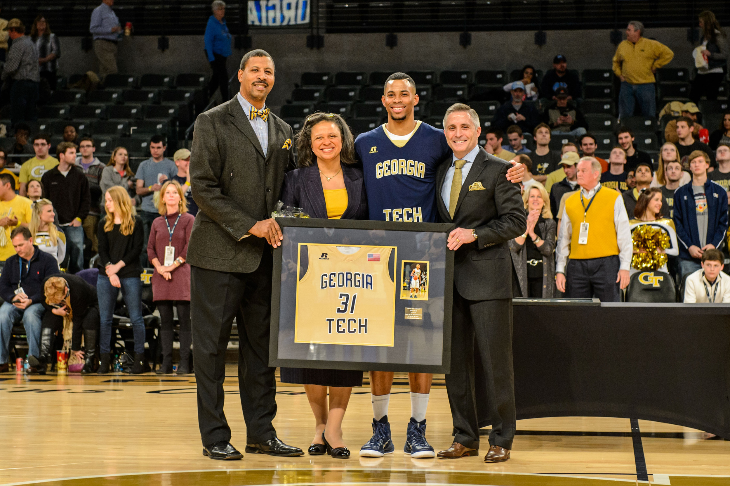 Coach Brian Gregory poses with Aaron Peek (31) and his parents on Senior Night