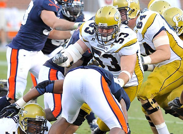 A.J. Smith (53) knocks down an unidentified Virginia player. (Photo by LensEffects)