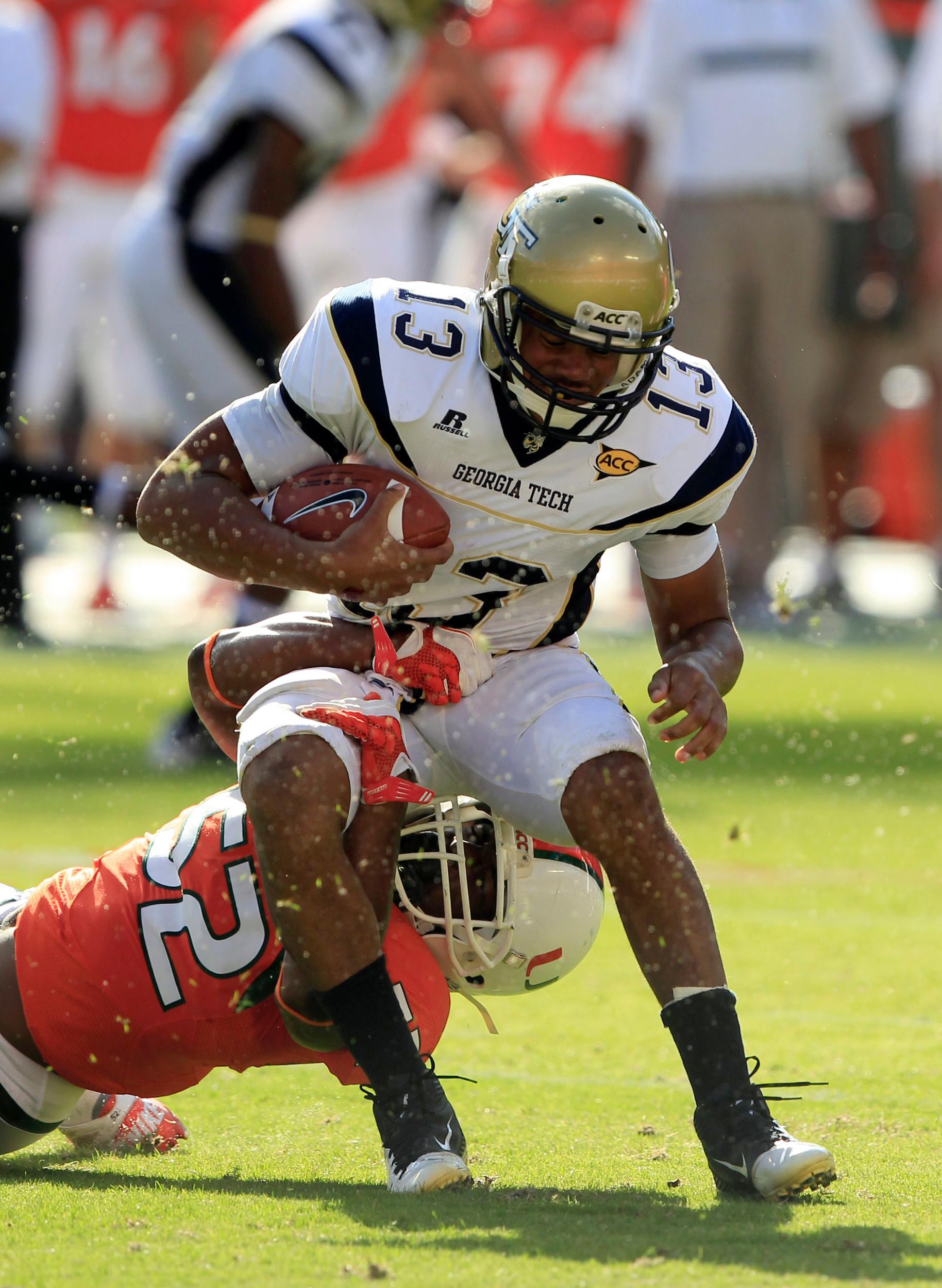 Georgia Tech quarterback Tevin Washington (13) tries to avoid the grasp of Miami linebacker Denzel Perryman. (AP Photo/Wilfredo Lee)
