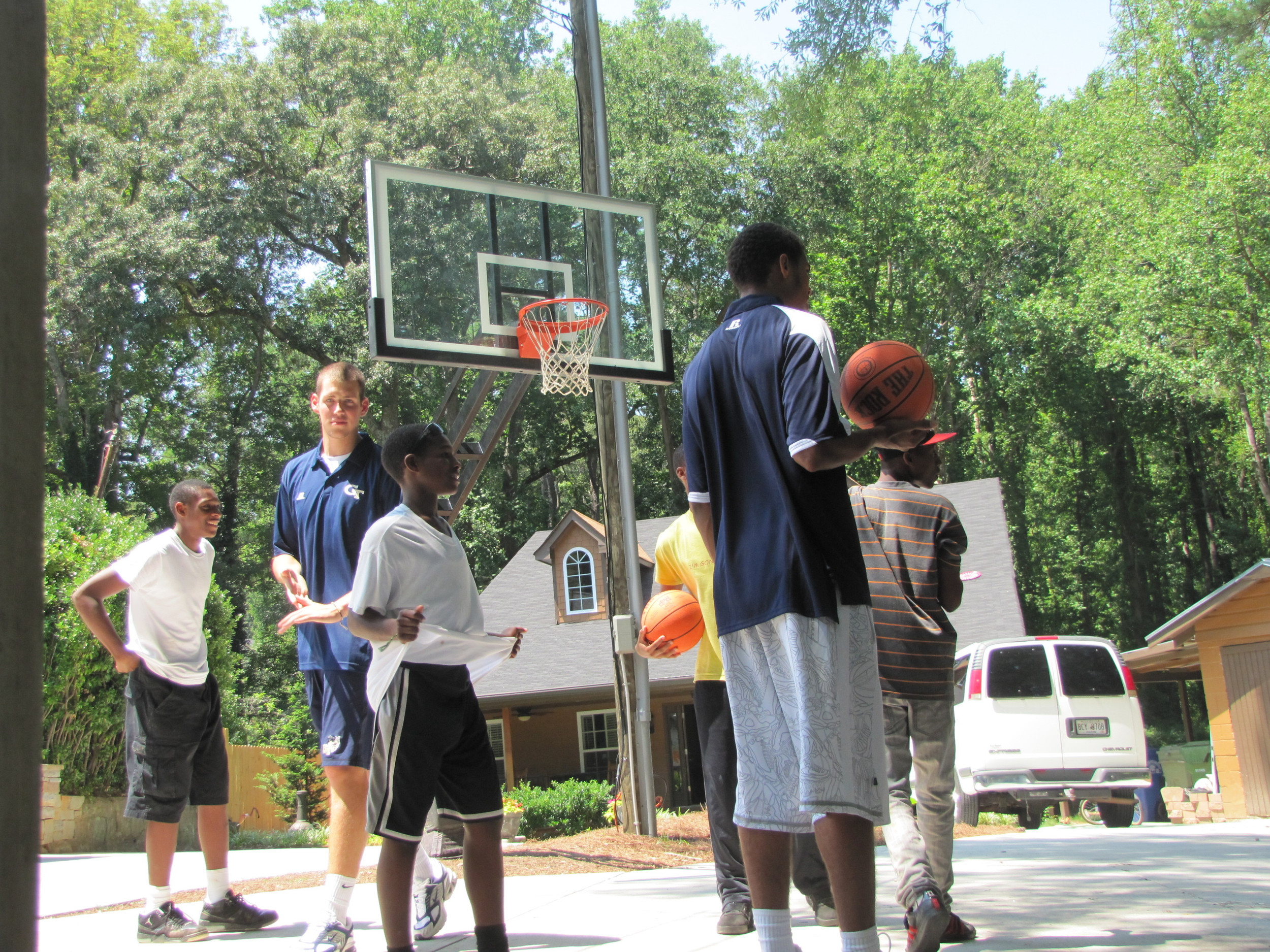 Kammeon Holsey, Daniel Miller, Brandon Reed and Glen Rice. Jr., play pick-up with the kids at Bright Futures Academy.