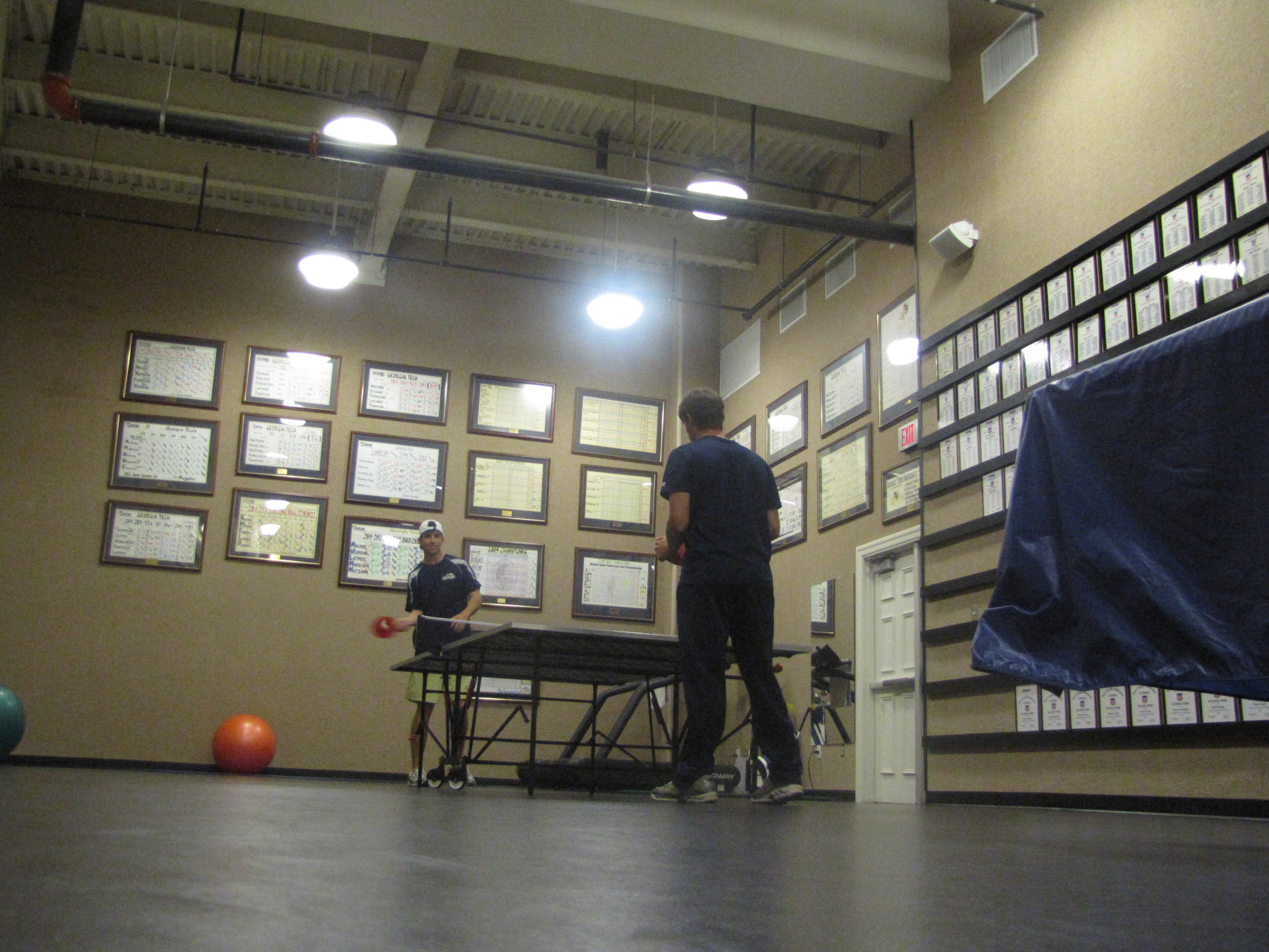 Tech golfers playing ping-pong in the team's workout room.