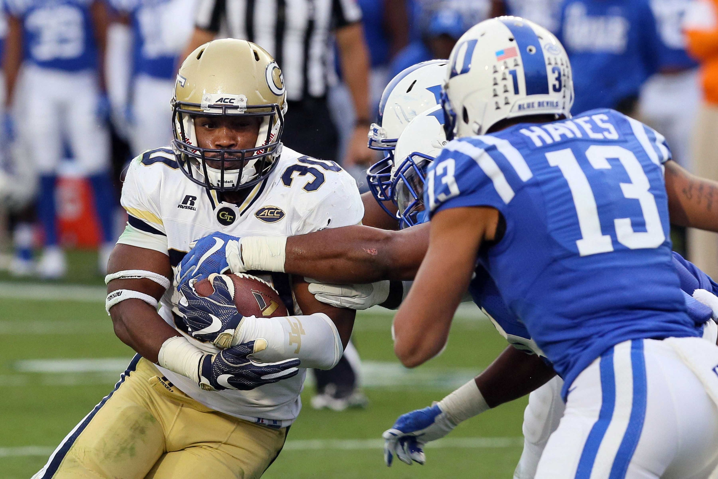 Nov 18, 2017; Durham, NC, USA; Georgia Tech Yellow Jackets running back KirVonte Benson (30) is tackled by a host of Duke Blue Devils defenders in the first half at Wallace Wade Stadium. Mandatory Credit: Mark Dolejs-USA TODAY Sports