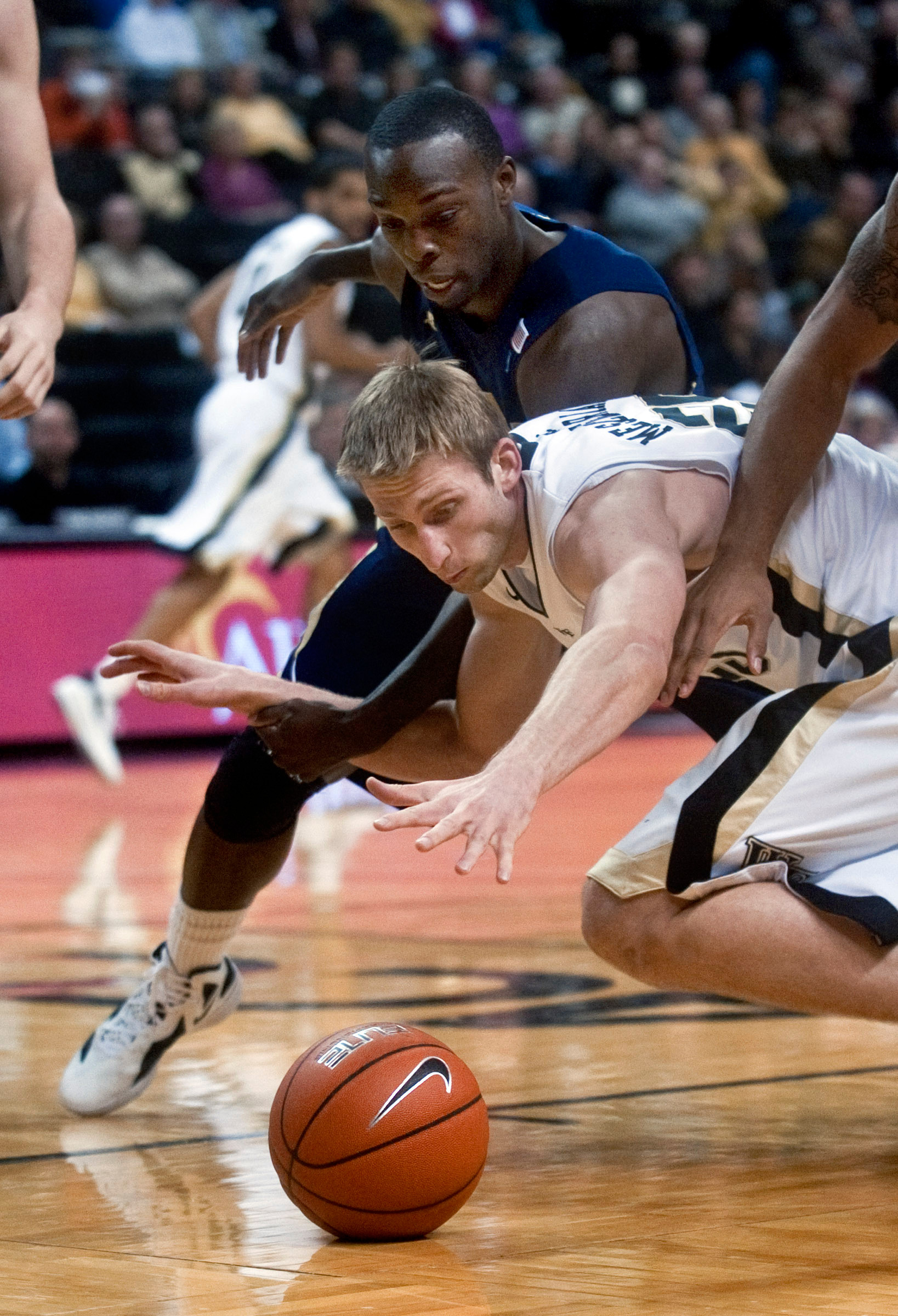 Wake Forest's Nikita Mescheriakov, front, and Georgia Tech's Mfon Udofia dive for a loose ball. (AP Photo/Winston-Salem Journal, Lauren Carroll)